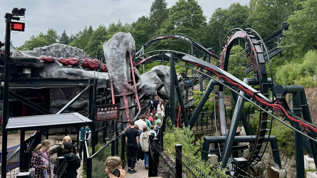 Nemesis Reborn ride with black and red-veined track and vertical loop. 
